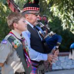 Dr. Raphael Pazo playing bagpipes while the Boy Scout Troop presented colors.