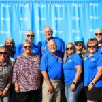 Board members posing in front of backdrop.